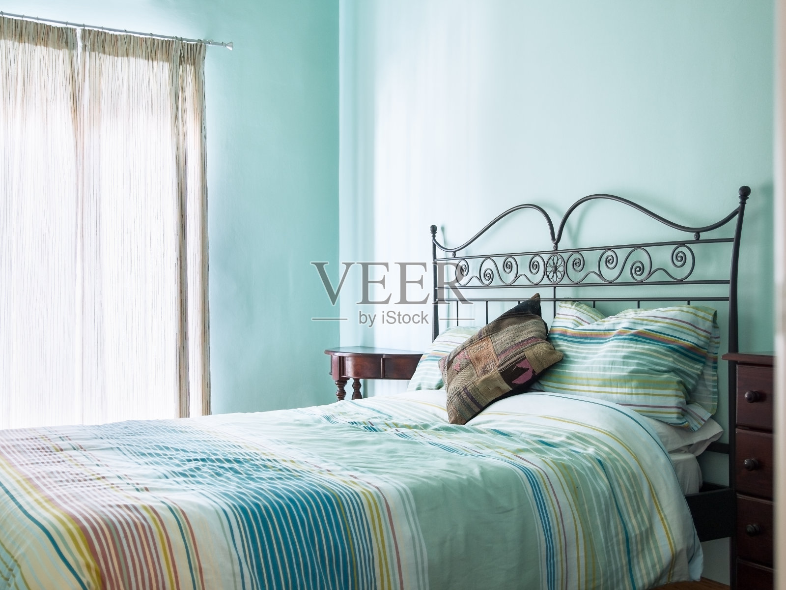 明亮通风的卧室，质朴的家具，绿色/绿松石漆和床和早餐软家具。照片摄影图片