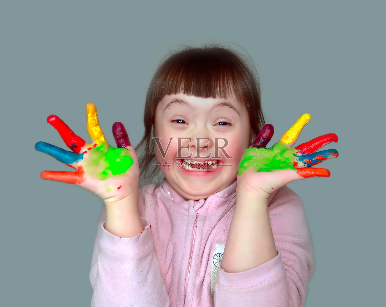 可爱的小女孩，涂了颜料的手。照片摄影图片