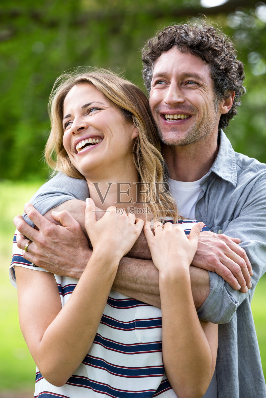 一对微笑的情侣在公园里拥抱照片摄影图片