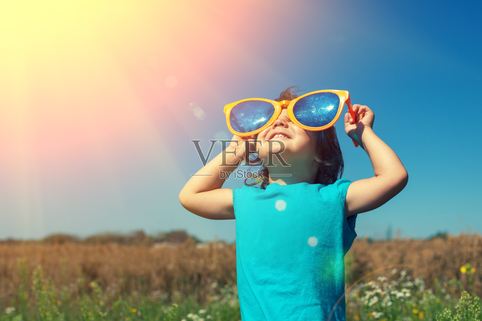 戴着大太阳镜的小女孩喜欢晒太阳照片摄影图片