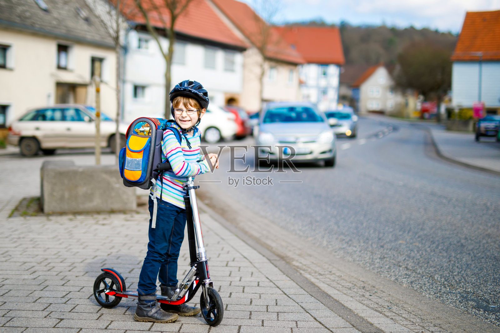 一个戴着头盔的小男孩骑着他的摩托车在城市里照片摄影图片