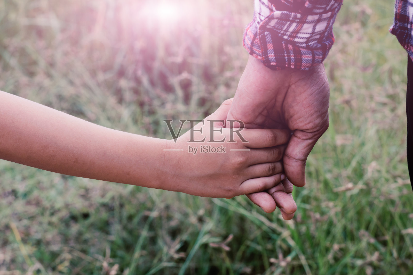 一个女孩牵着父亲的手，老式滤镜。照片摄影图片