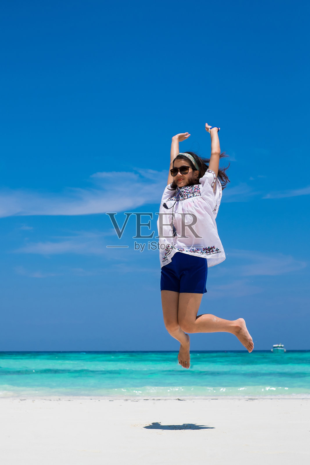 亚洲女人在热带海滩和白色沙滩上跳照片摄影图片