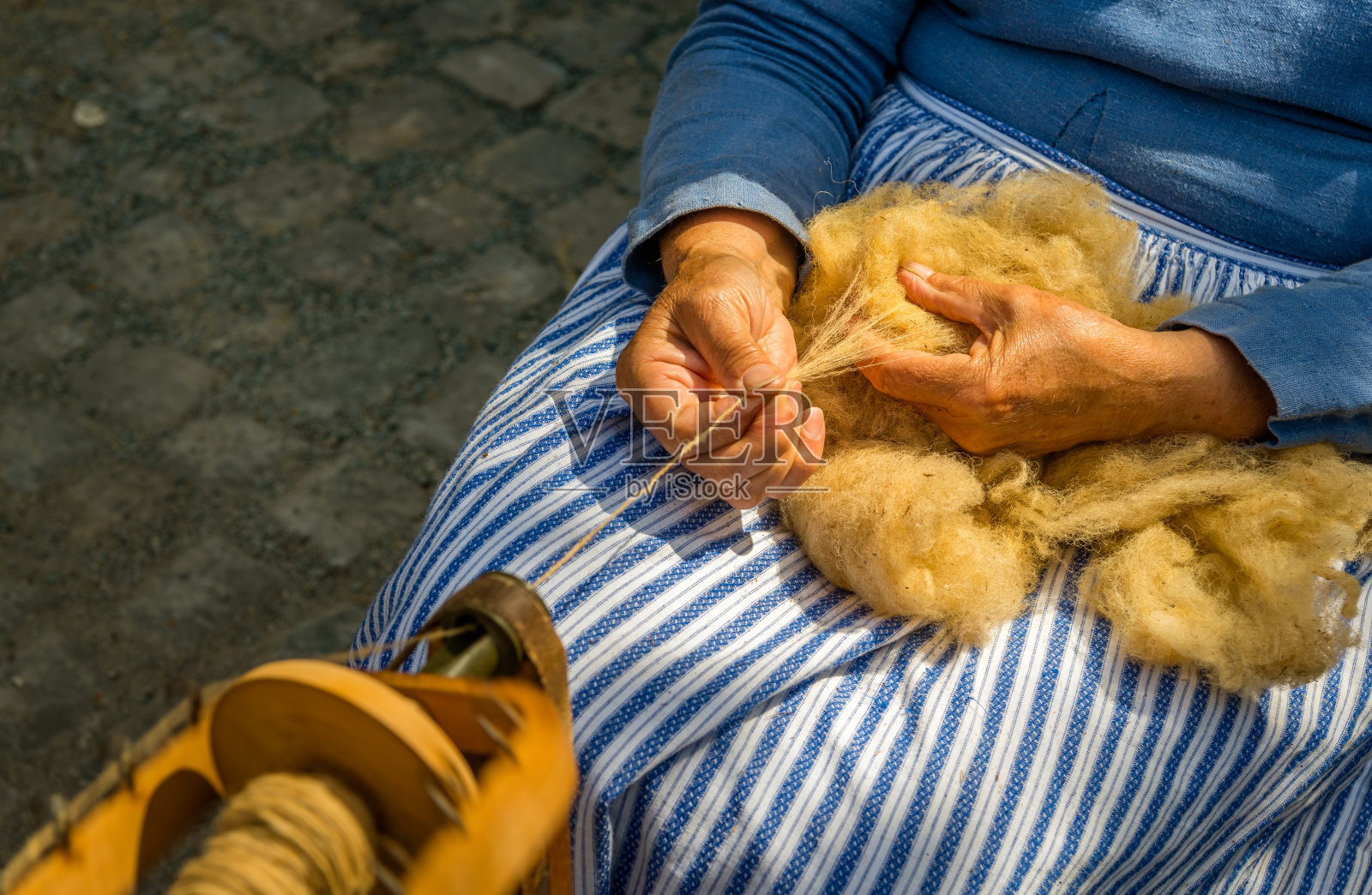 女性用手在纺车上纺生羊毛照片摄影图片
