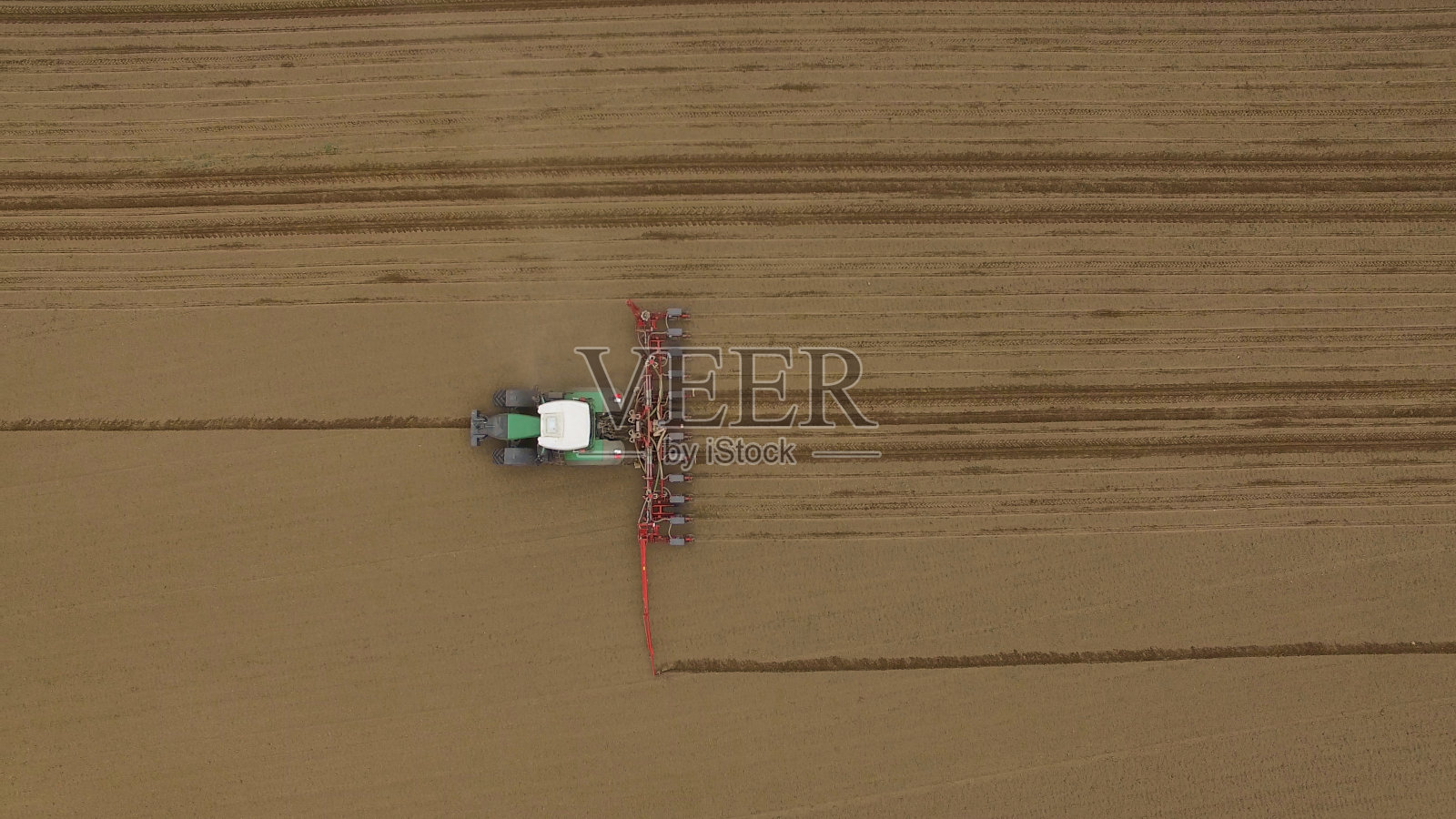 鸟瞰图拖拉机在耕作的田野在春季农业机械照片摄影图片