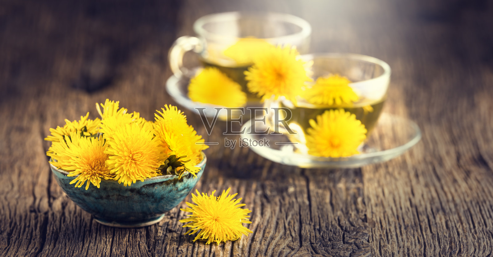蒲公英茶。黄色的蒲公英花和茶杯照片摄影图片