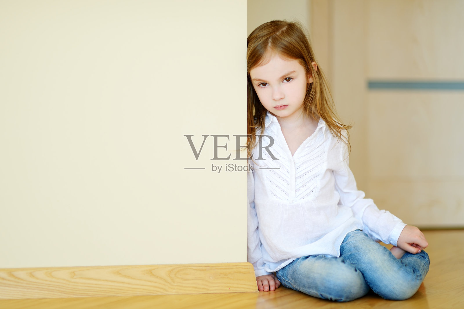 悲伤的小女孩坐在地板上照片摄影图片