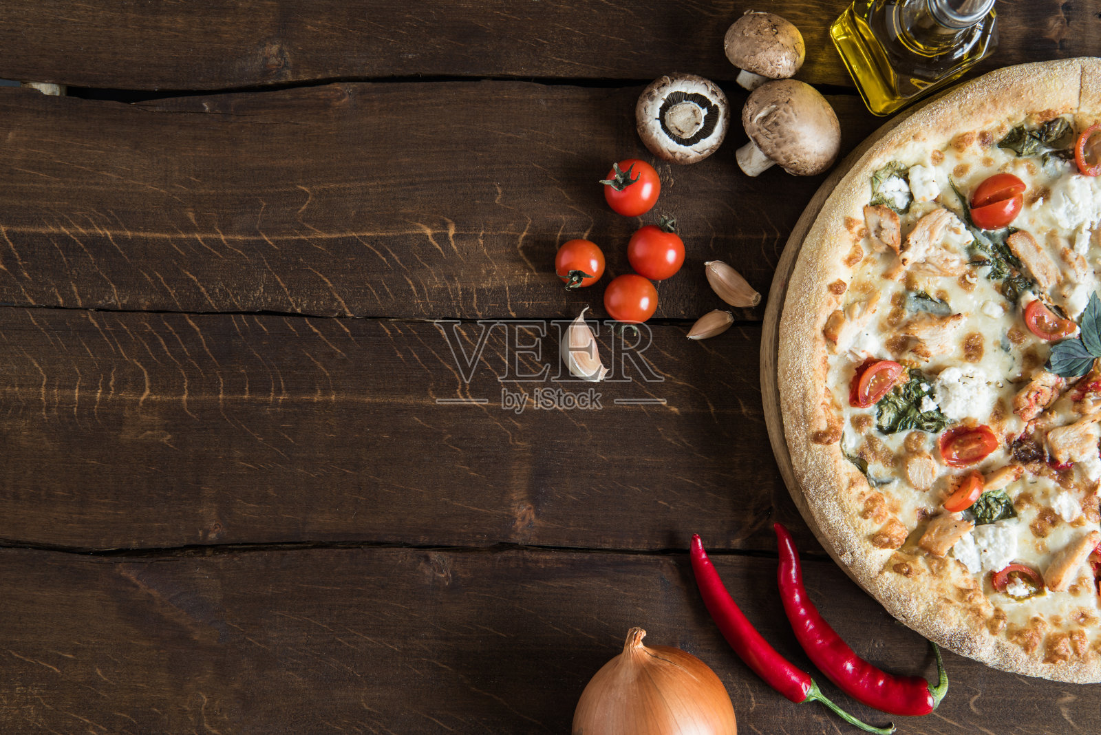 俯视图自制的意大利披萨与各种新鲜的原料在木制表面照片摄影图片