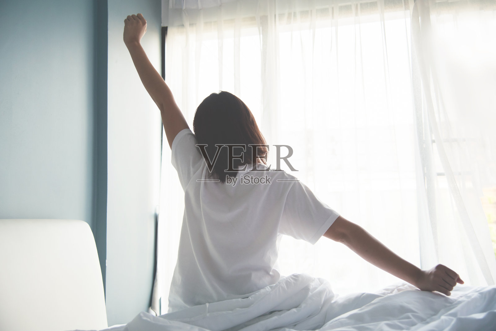 早上醒来的亚洲女人。伸出手臂。照片摄影图片