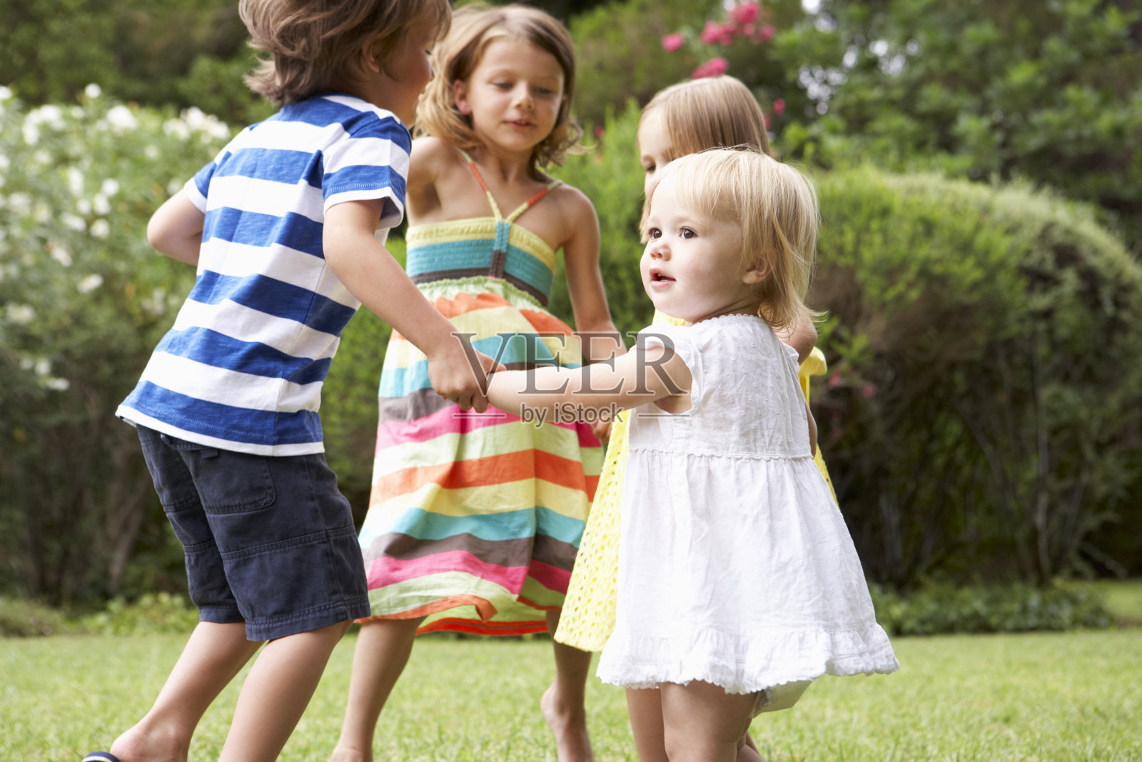 四个孩子围成一圈玩耍，享受着夏日的快乐照片摄影图片