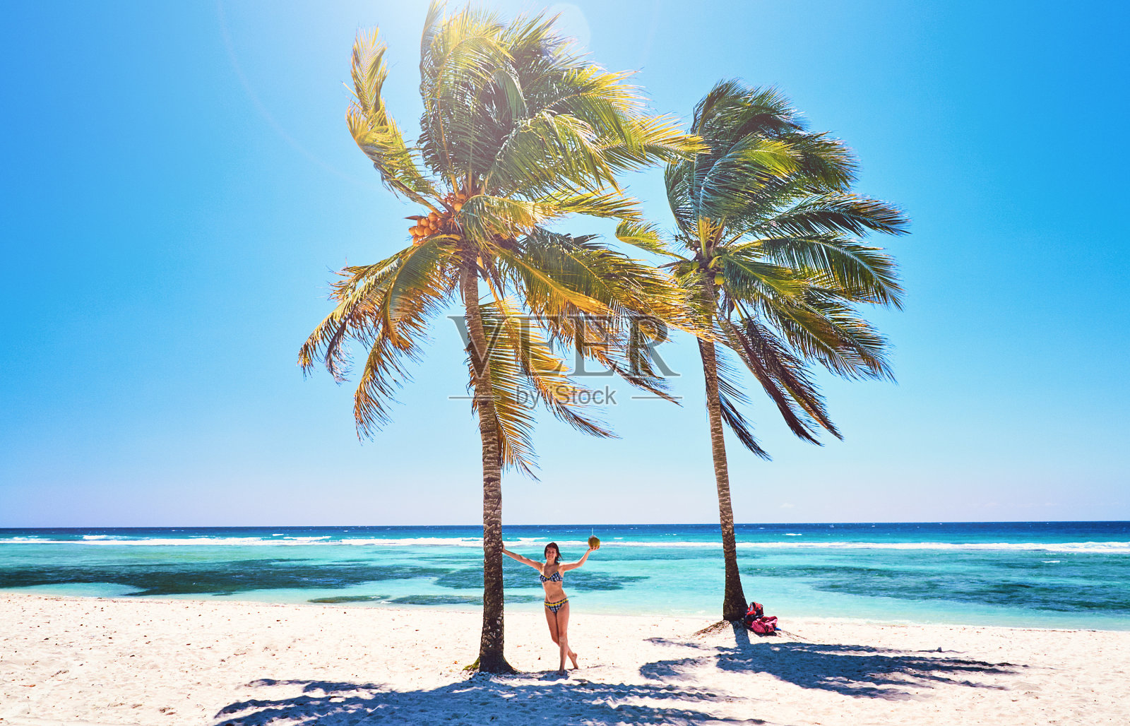 年轻女子在沙滩上欢快快乐的椰子树。古巴，加勒比海海滩照片摄影图片