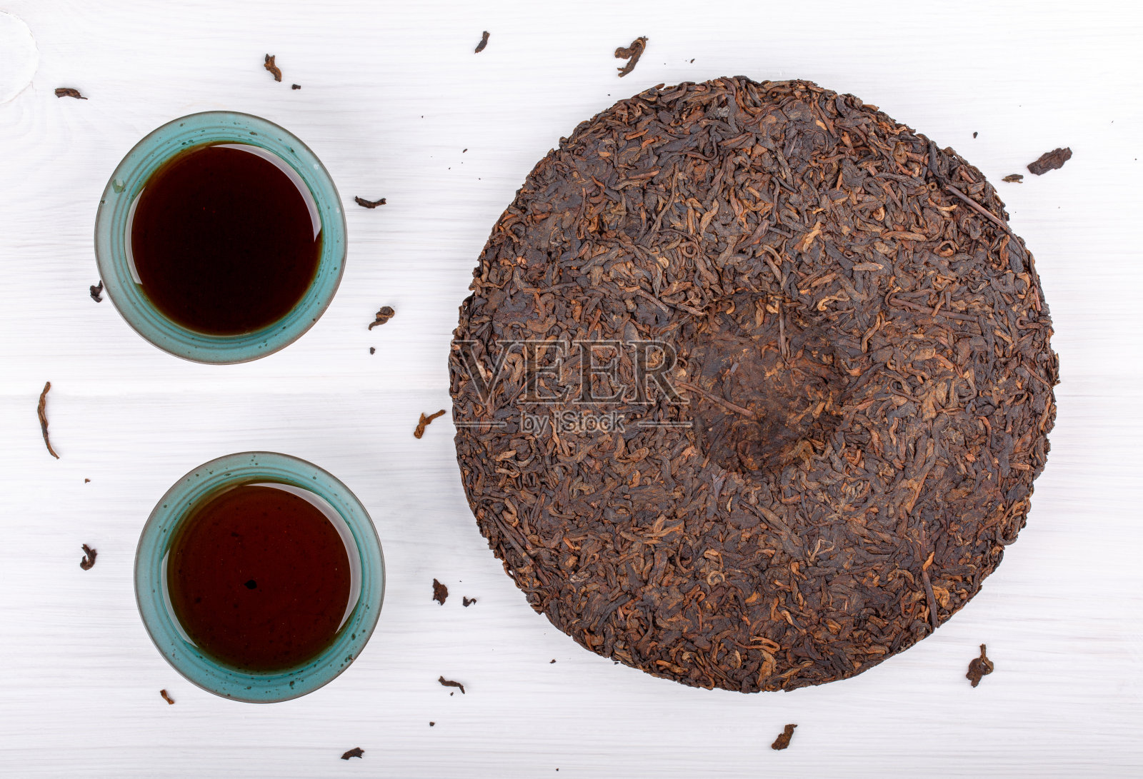 圆盘普洱茶和两杯白茶。中国发酵普洱茶。前视图。照片摄影图片