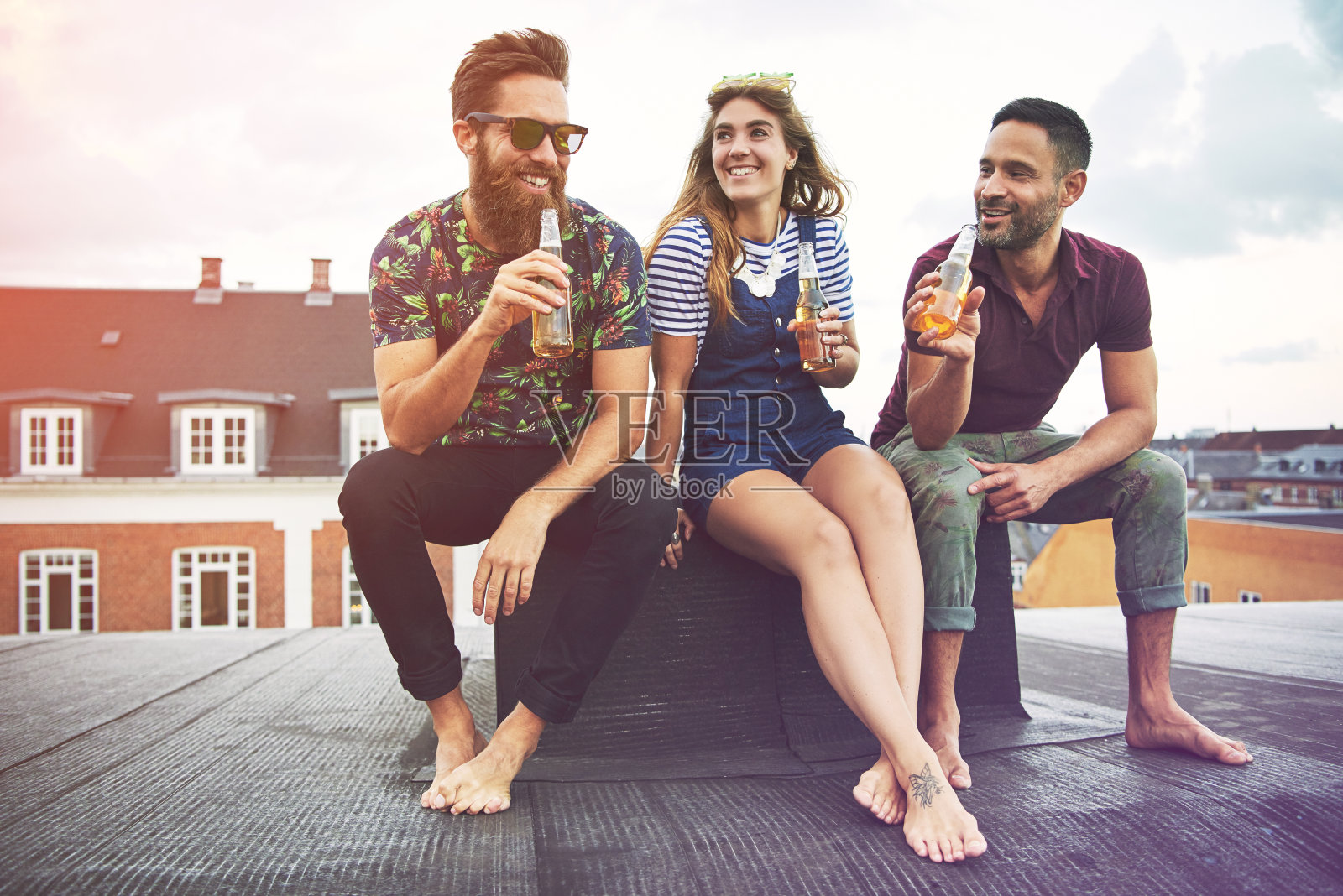 三个光脚的成年人一起喝啤酒照片摄影图片