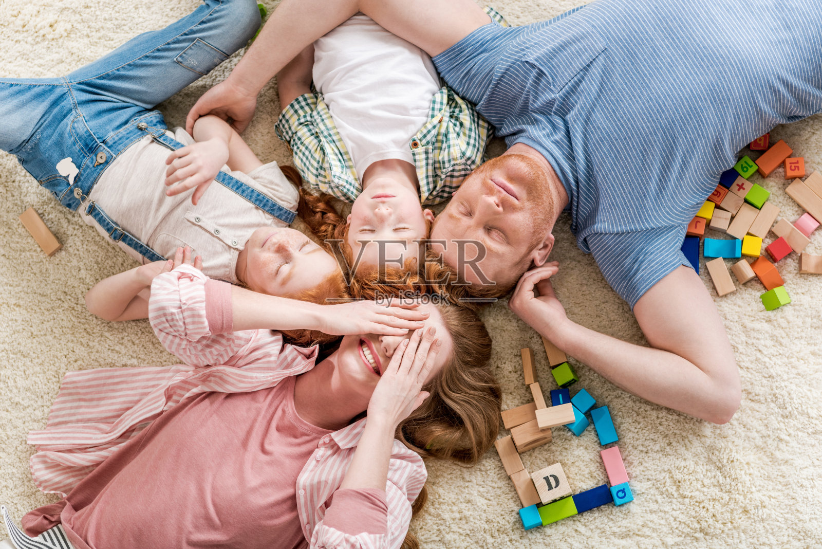 俯视图的幸福家庭躺在地板上，大全家福的概念照片摄影图片
