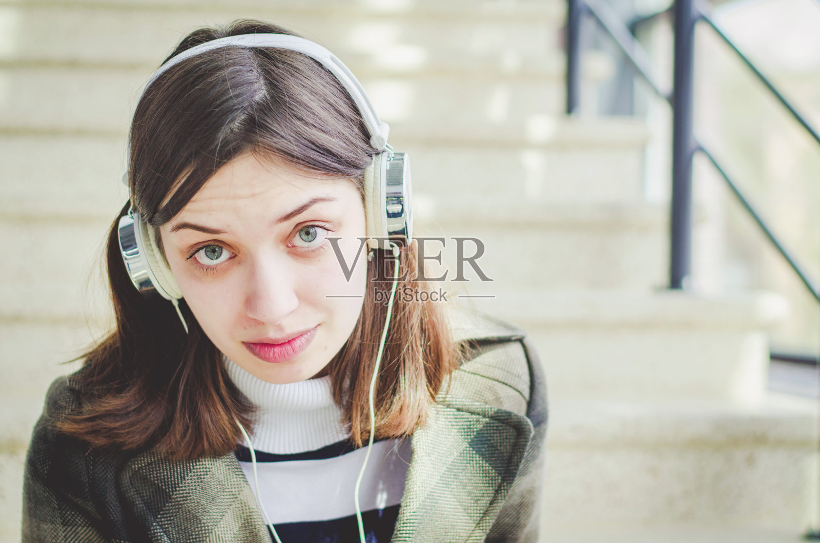 开朗快乐的黑发苗条女孩在一个购物中心有乐趣听音乐耳机照片摄影图片
