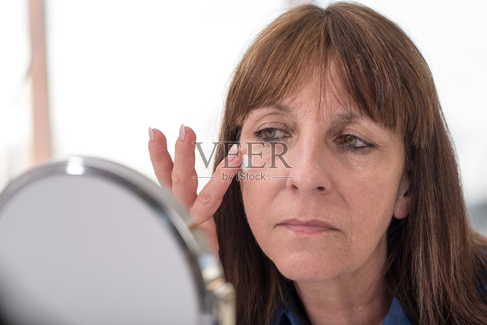 一位女士在脸上涂抹抗衰老霜照片摄影图片