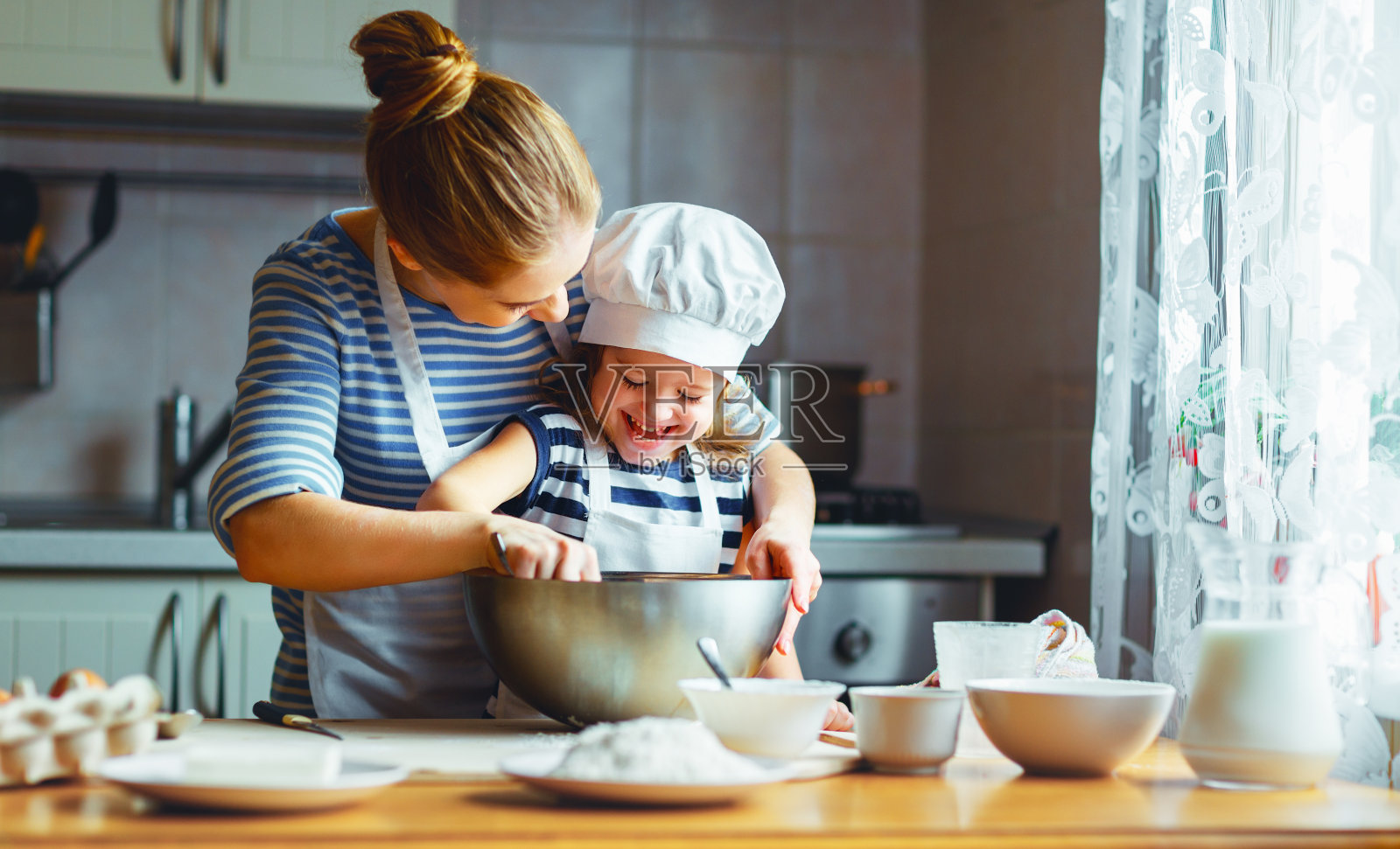 幸福家庭在厨房。母亲和孩子准备面团，烤饼干照片摄影图片