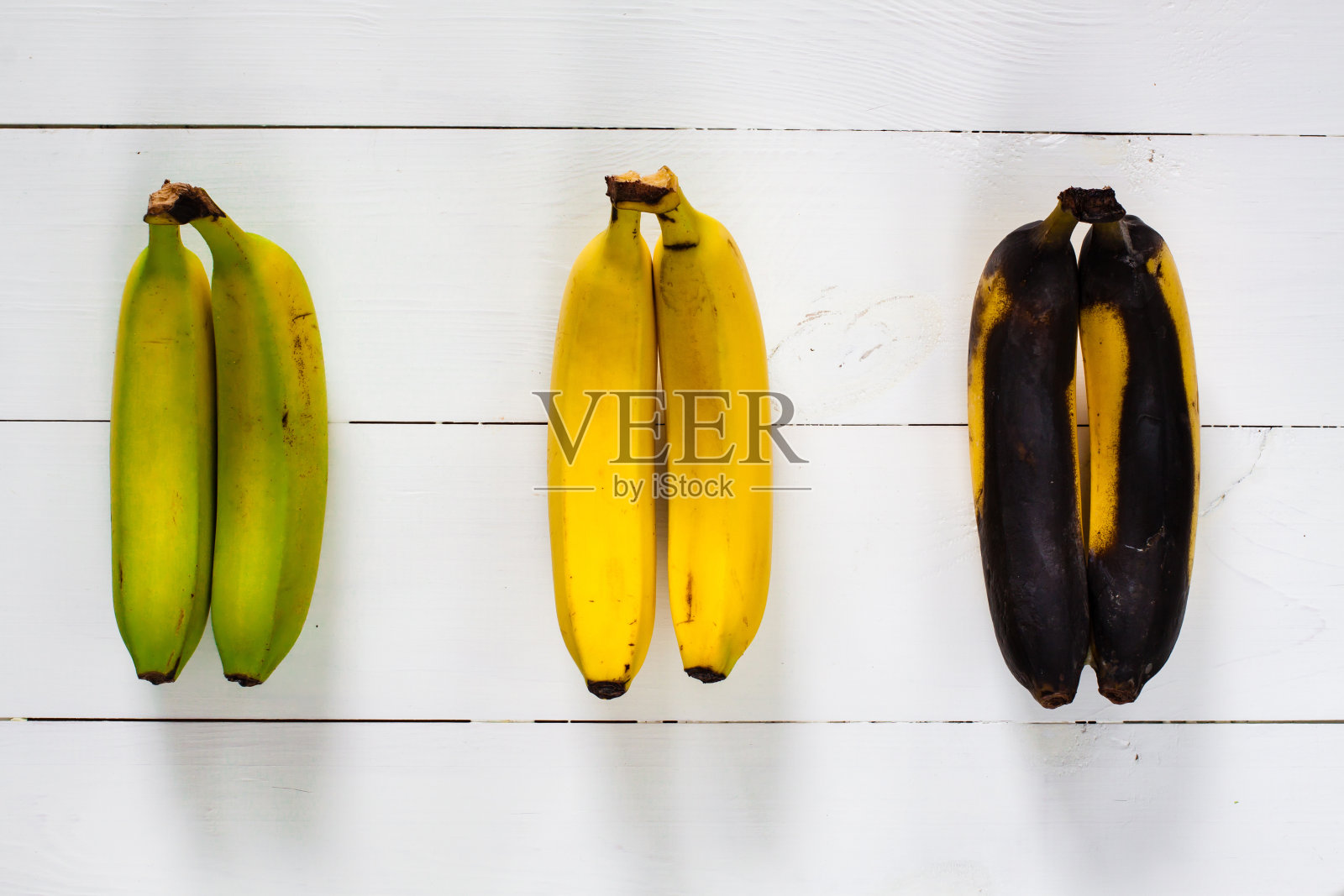 绿色、黄色和黑色的香蕉。照片摄影图片