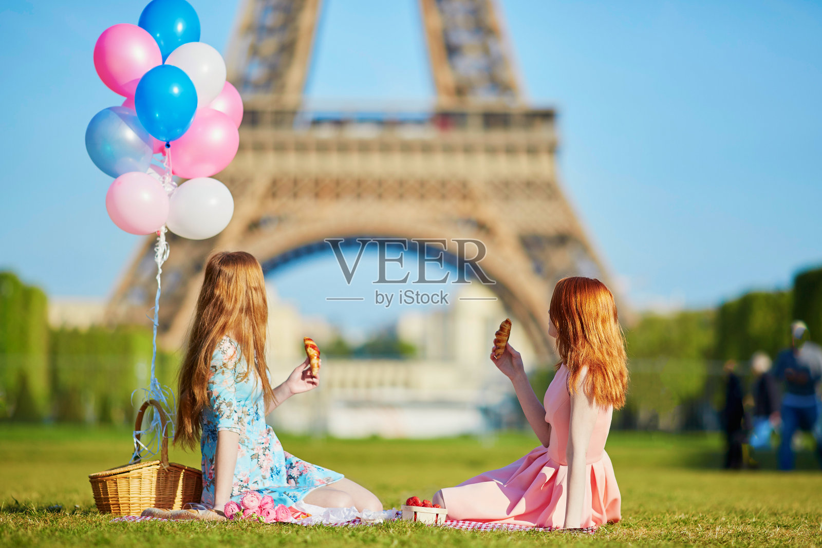 在法国巴黎埃菲尔铁塔附近野餐的妇女照片摄影图片