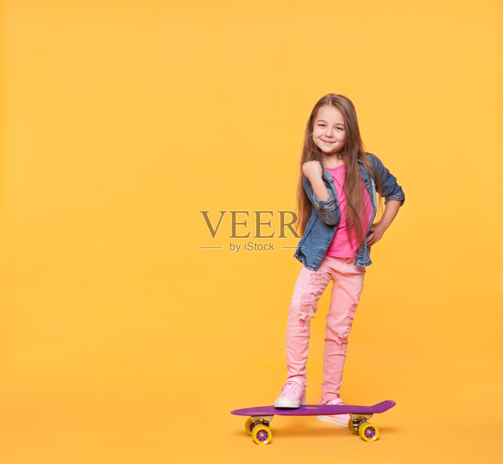 小女孩穿着五颜六色的衣服，表现出成功的姿态照片摄影图片