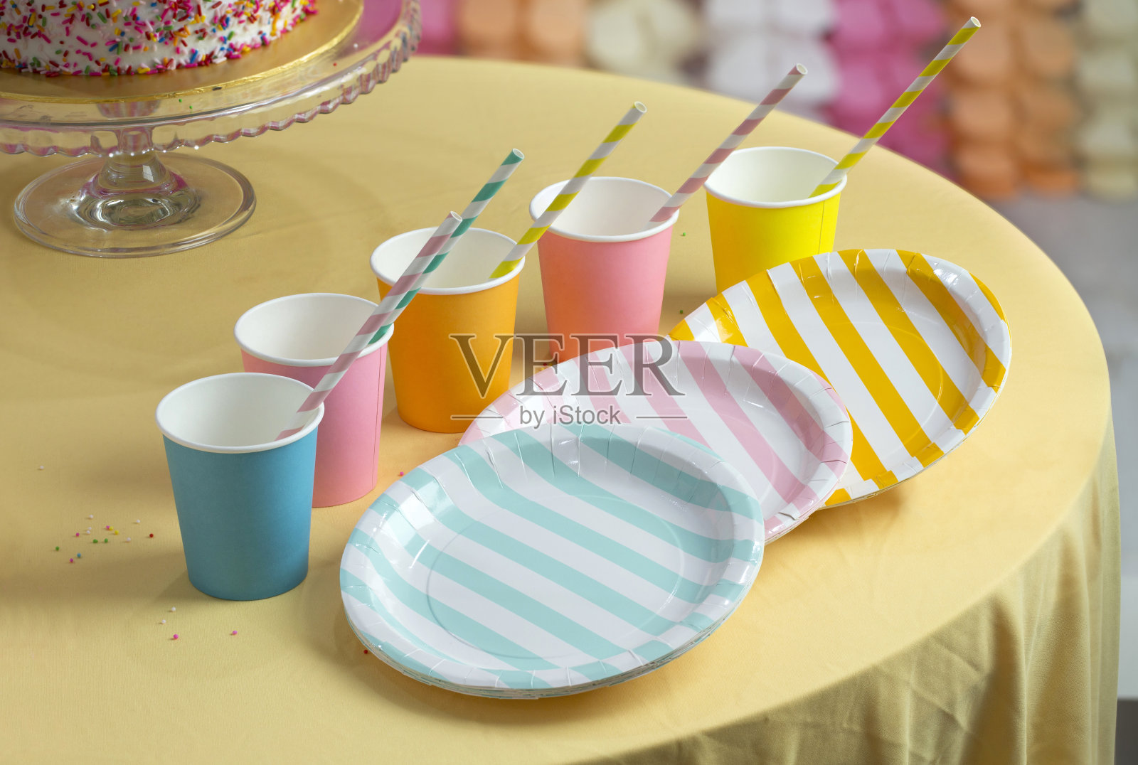 桌上放着五颜六色的派对纸杯和盘子。照片摄影图片