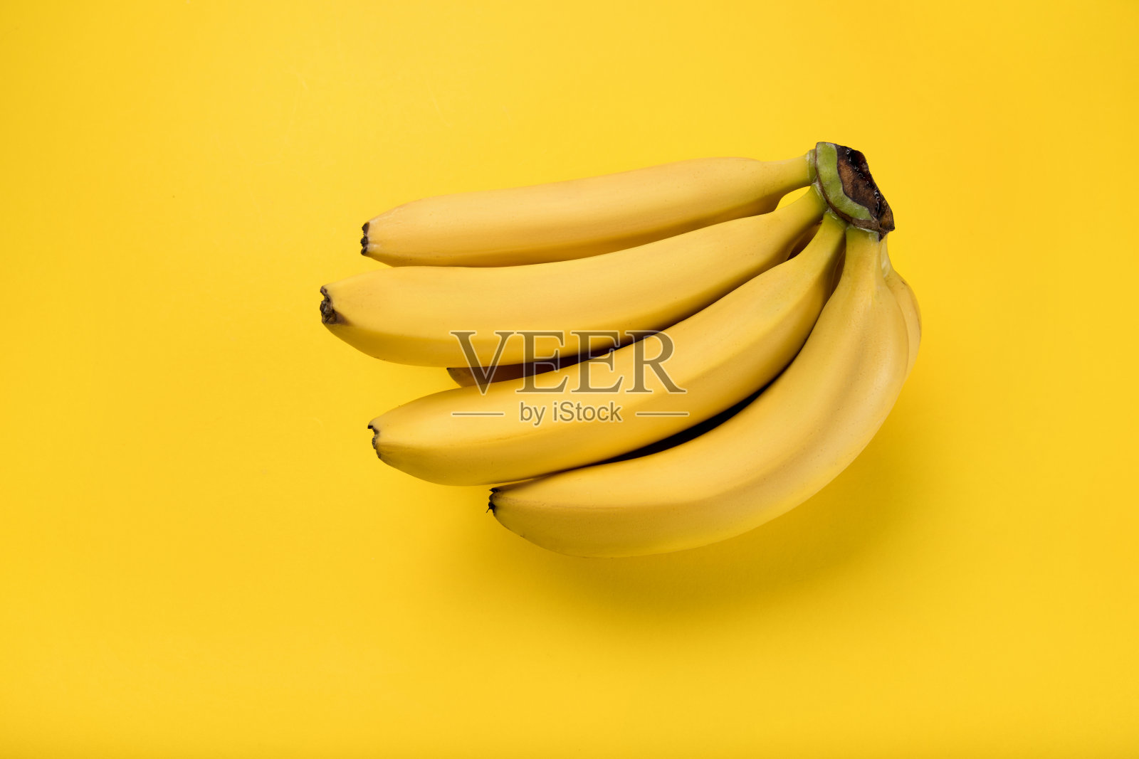 近距离观察串新鲜成熟的香蕉孤立在黄色照片摄影图片