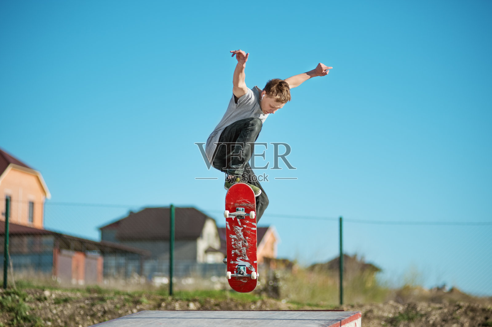 一个十几岁的滑板爱好者在城市郊区的一个滑板公园里玩奥利把戏照片摄影图片