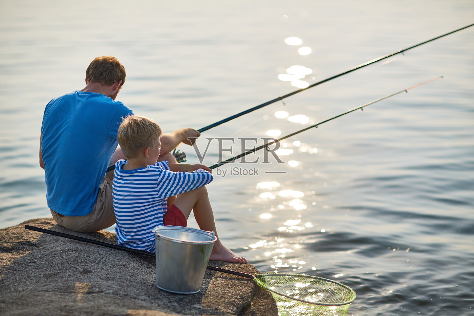 父亲和儿子在湖上钓鱼照片摄影图片