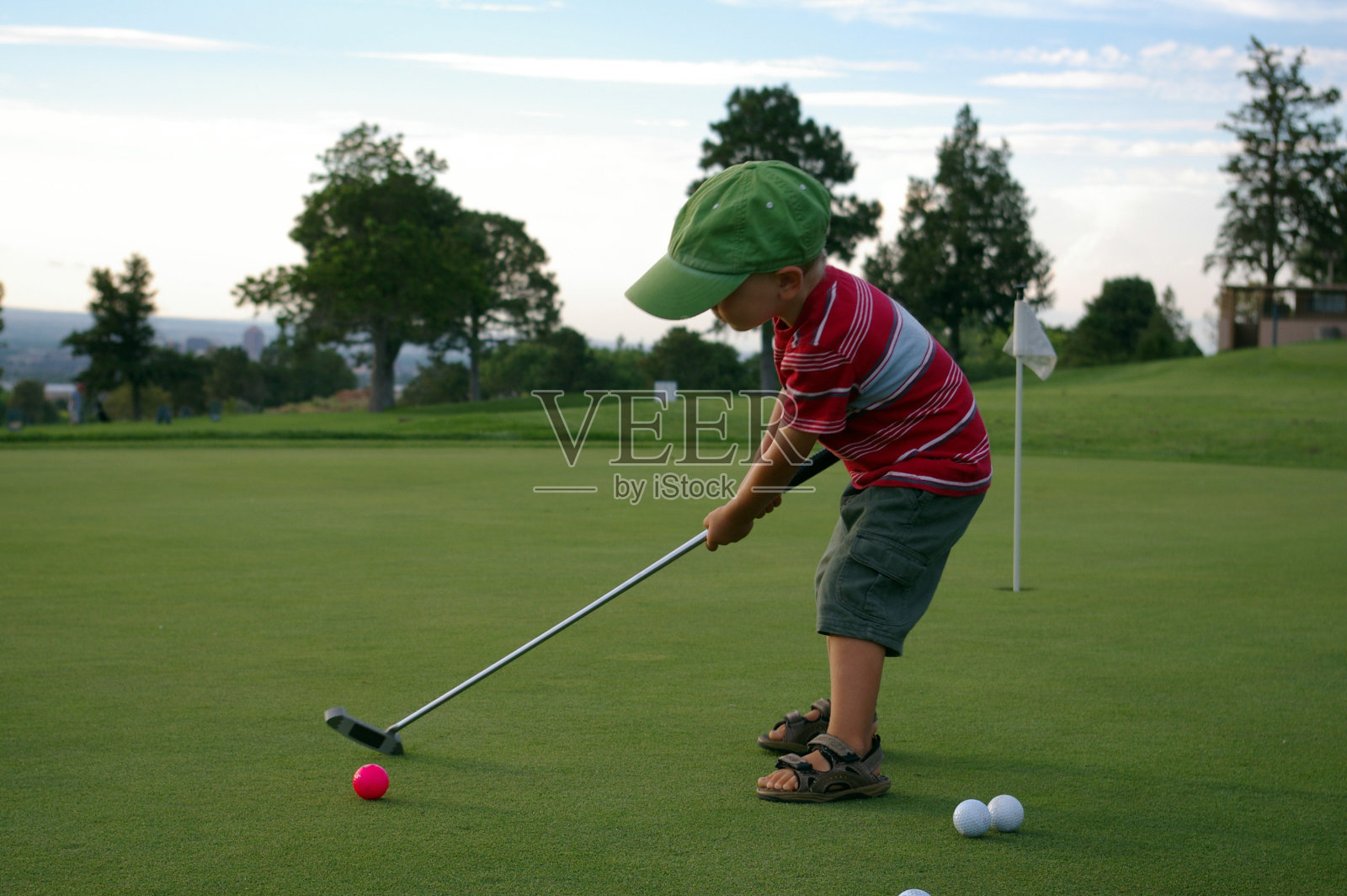 可爱的小男孩打高尔夫球照片摄影图片