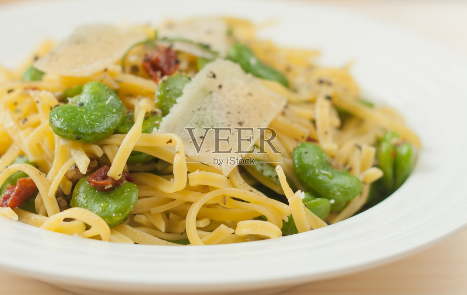 意大利宽面，意大利干酪，蚕豆和番茄。照片摄影图片