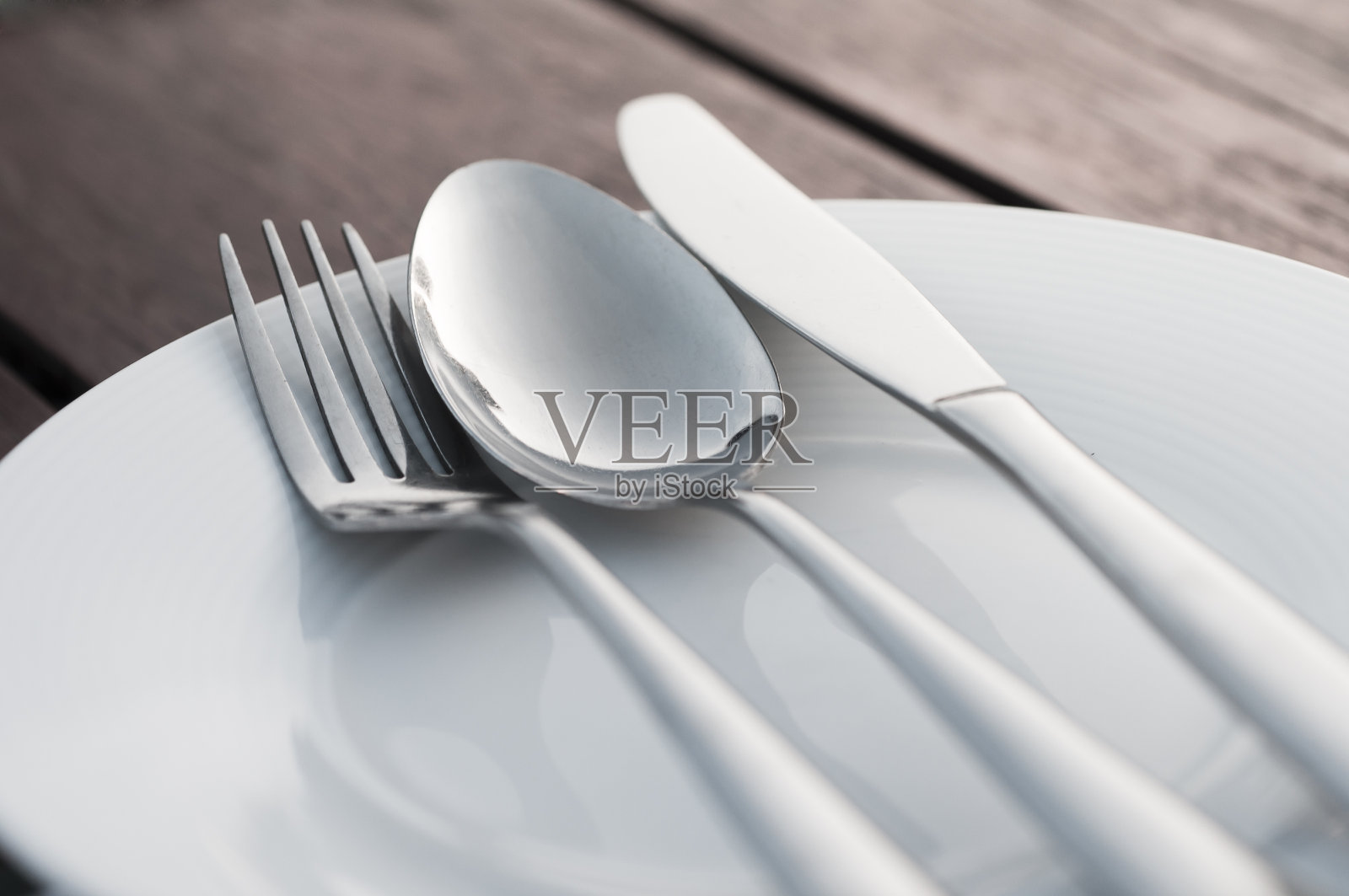 叉子、勺子和刀放在瓷盘上照片摄影图片
