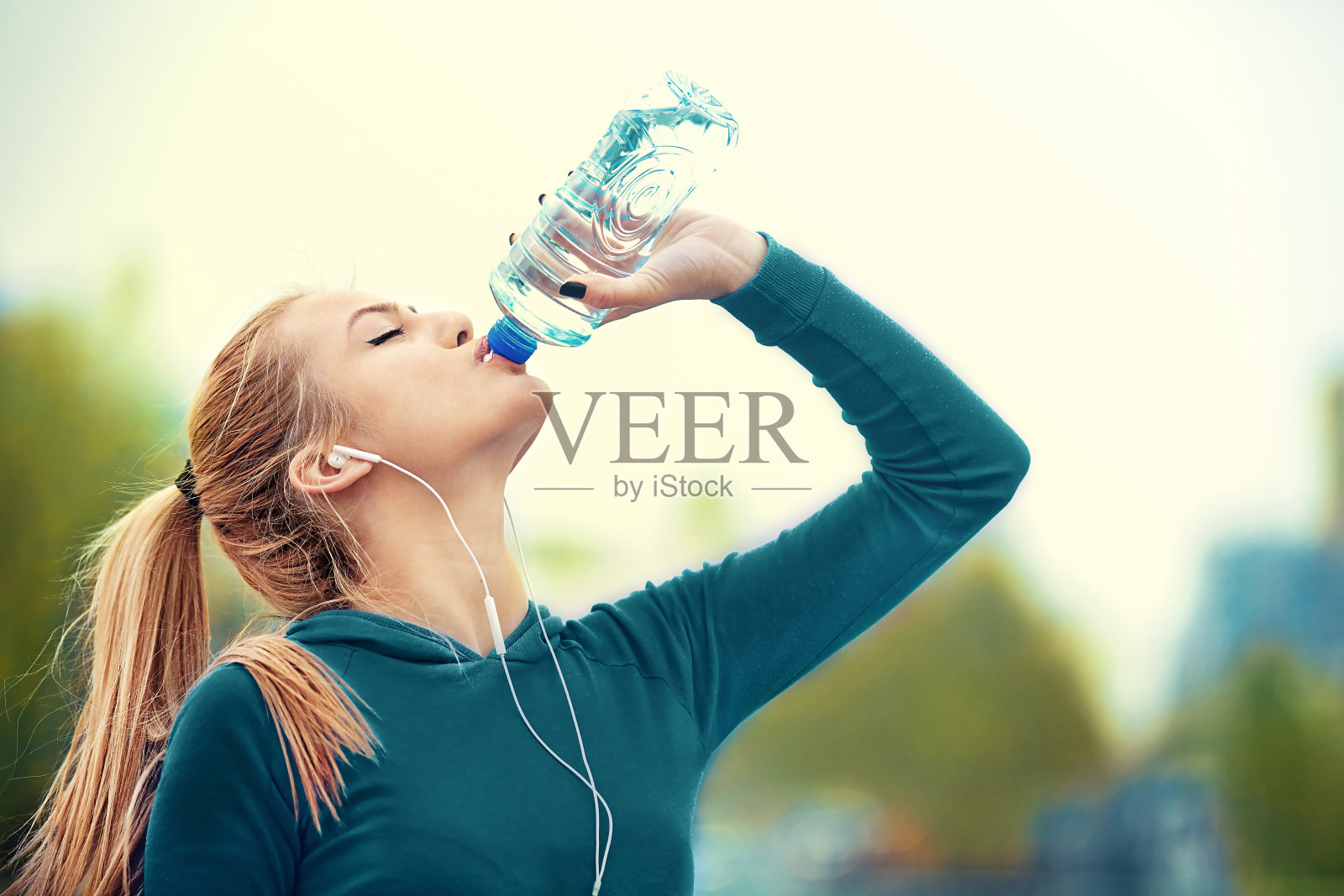 金发女子慢跑后正在喝水照片摄影图片