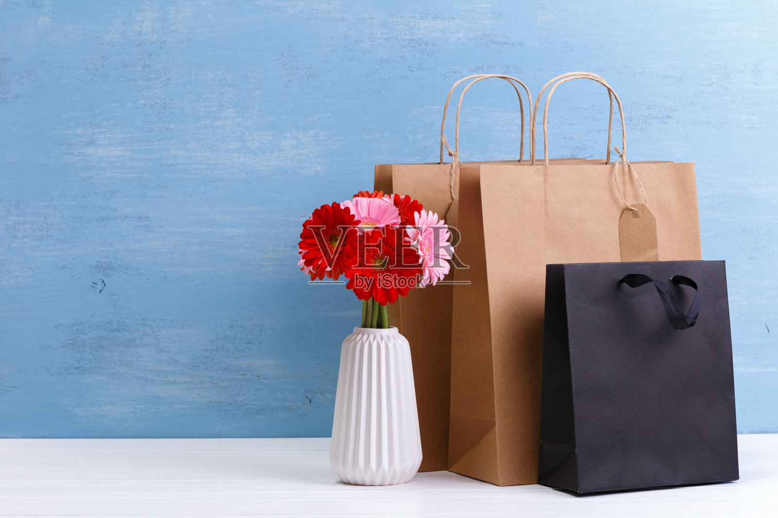 空白购物袋的模型。非洲菊的花。照片摄影图片