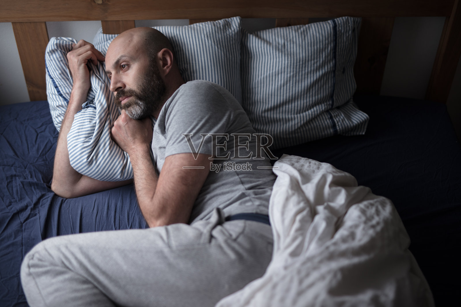 四十多岁的阿拉伯人在床上遭受抑郁症照片摄影图片