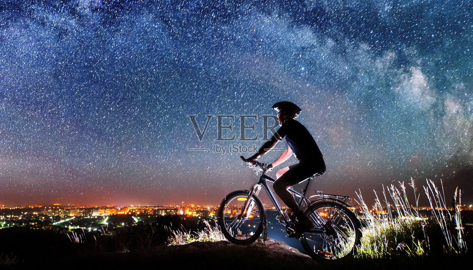 骑自行车的人在星空下骑着自行车照片摄影图片