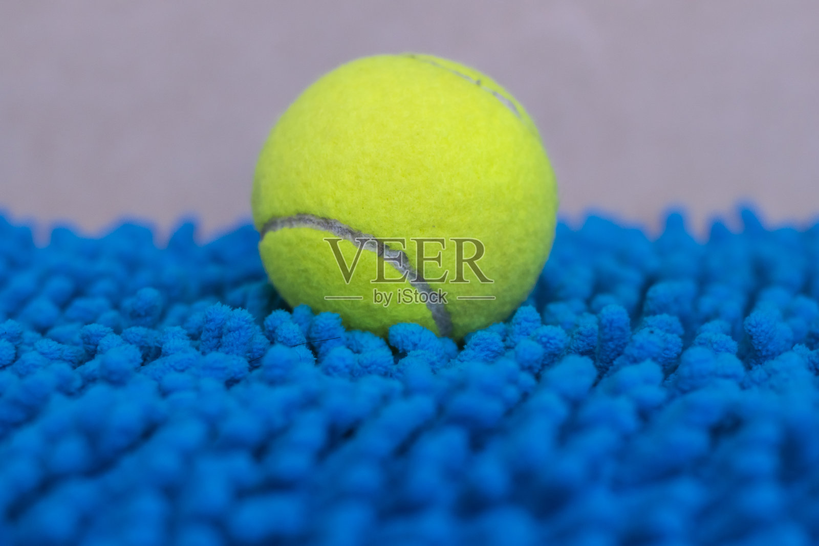 网球放在蓝色羊毛的门垫上照片摄影图片