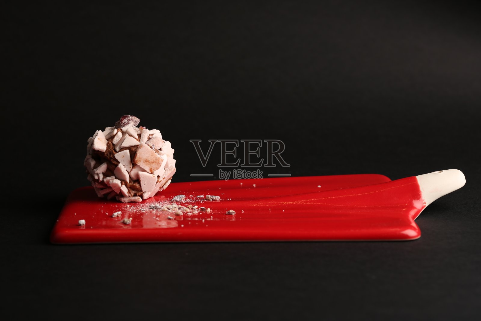 甜的甜点。美味的蛋白酥皮放在红色的盘子上，黑色的背景照片摄影图片