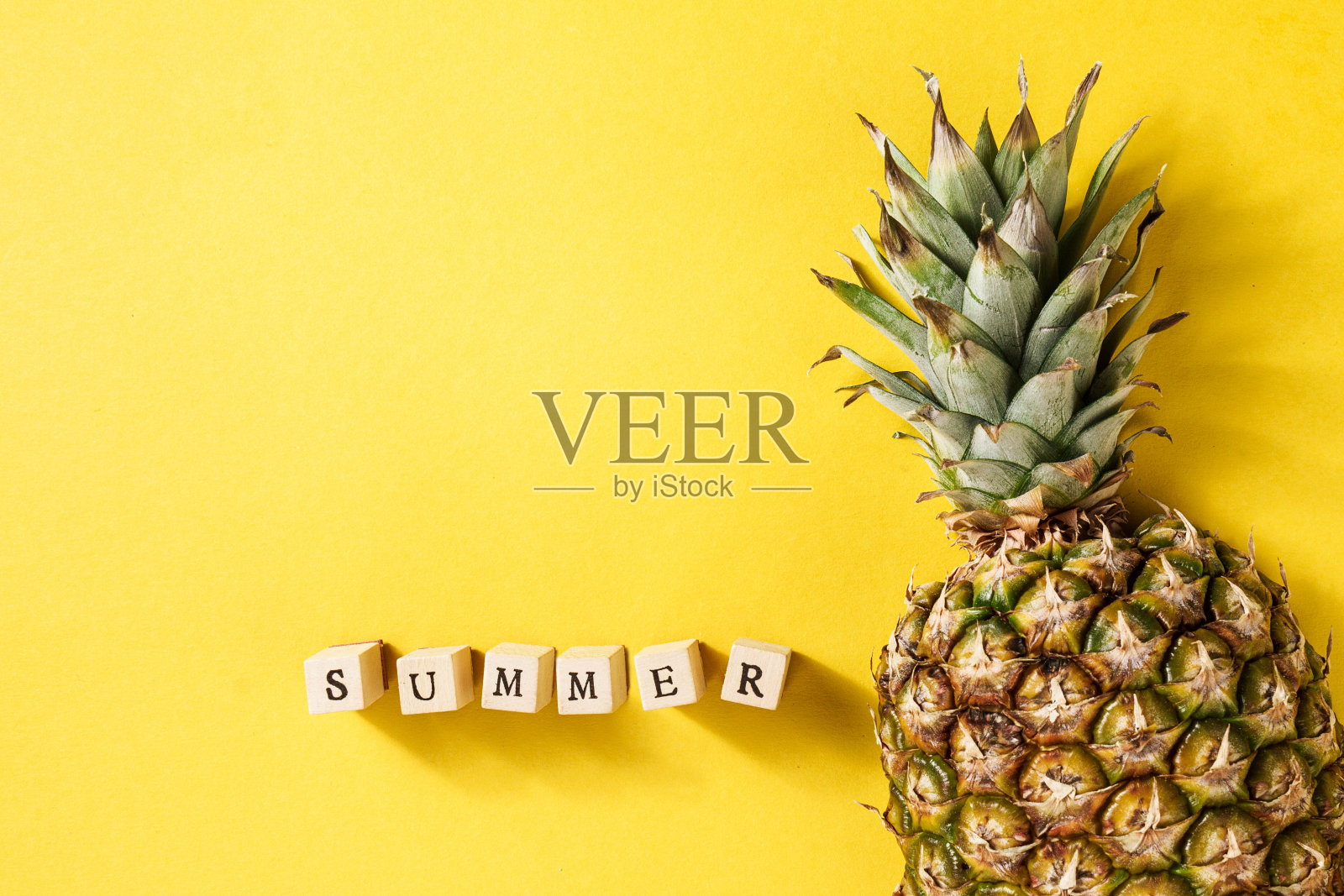 夏天的概念。概念。美味可口的一半菠萝在黄色明亮的背景与木字母。平的。照片摄影图片