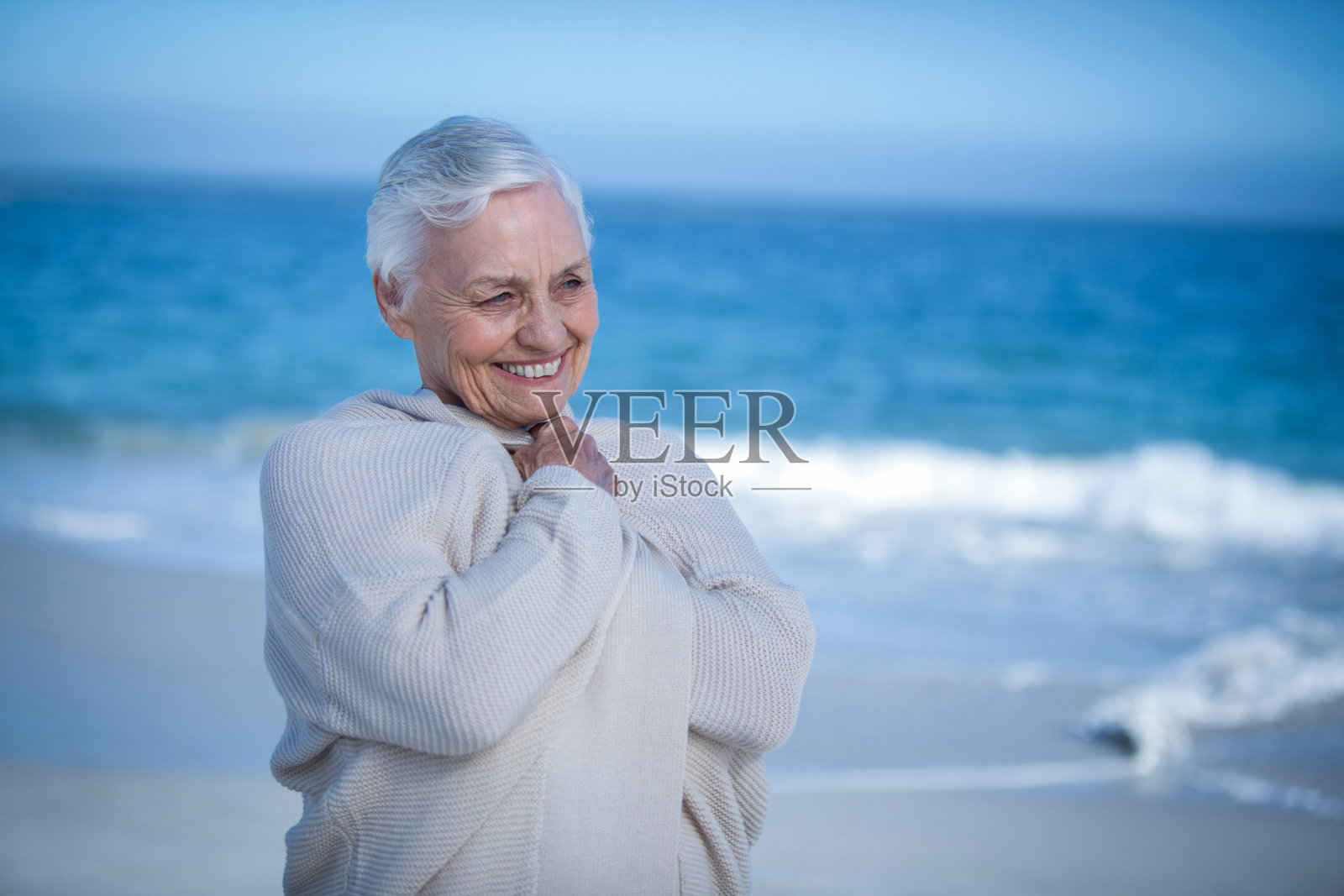 在海滩上放松的老妇人照片摄影图片