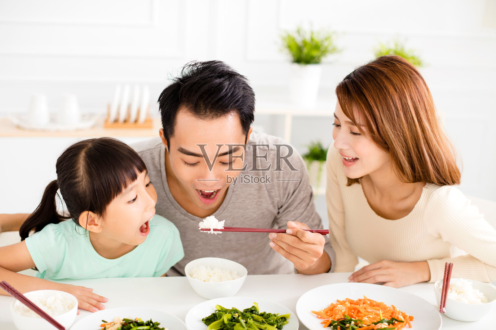 快乐的亚洲青年家庭享受他们的午餐照片摄影图片