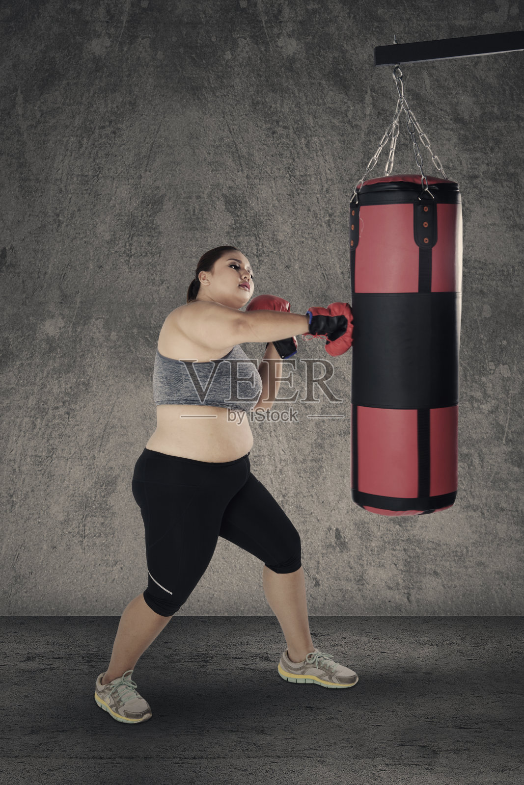 胖女人打拳击袋照片摄影图片