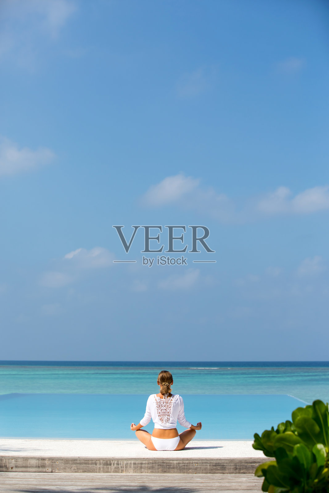 冥想。一个女人的照片是谁坐在荷花的位置上的海岸。马尔代夫照片摄影图片
