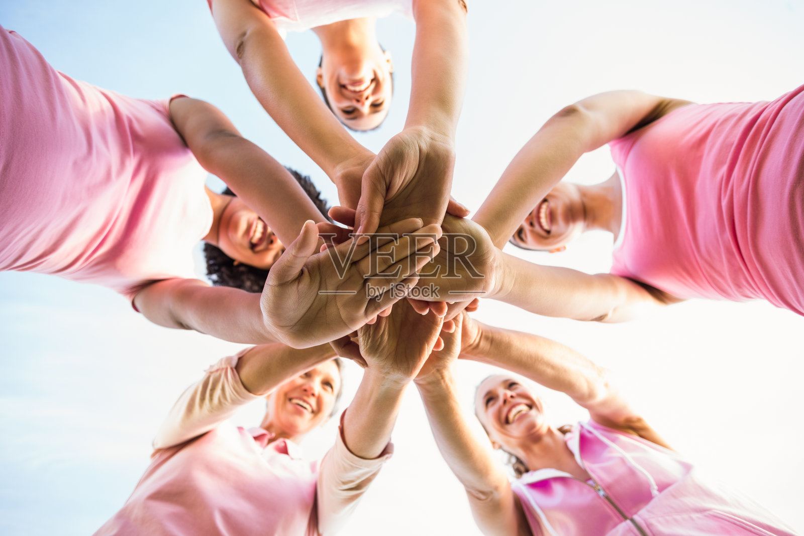 为乳腺癌而穿粉色衣服的女性，双手合十照片摄影图片