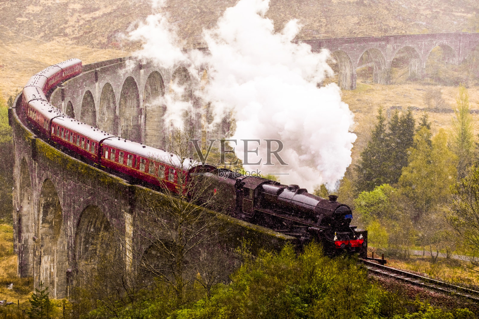 苏格兰的格伦芬南高架桥上有一辆蒸汽火车照片摄影图片