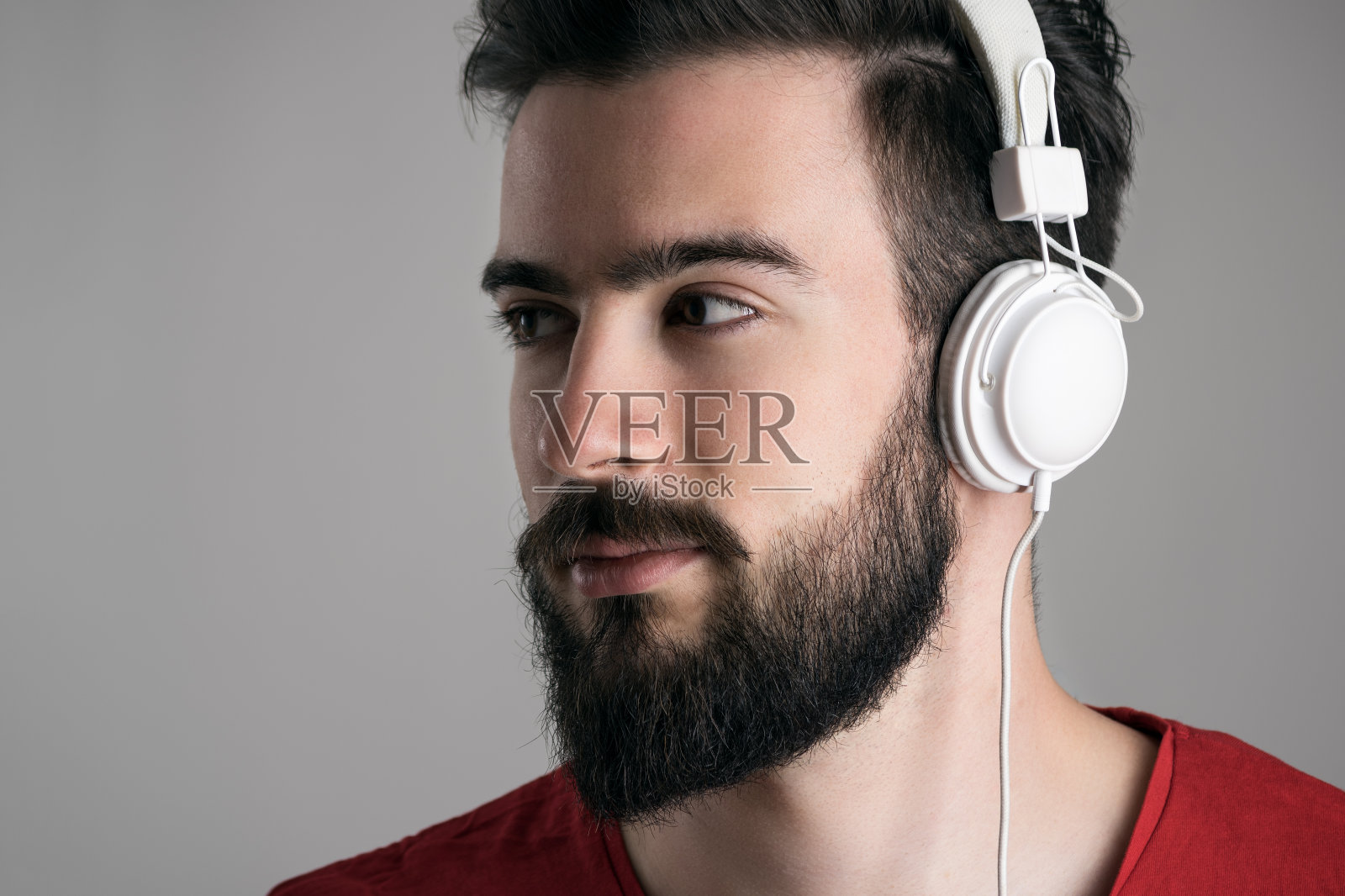 年轻英俊的胡子男子与耳机的特写侧面视图照片摄影图片
