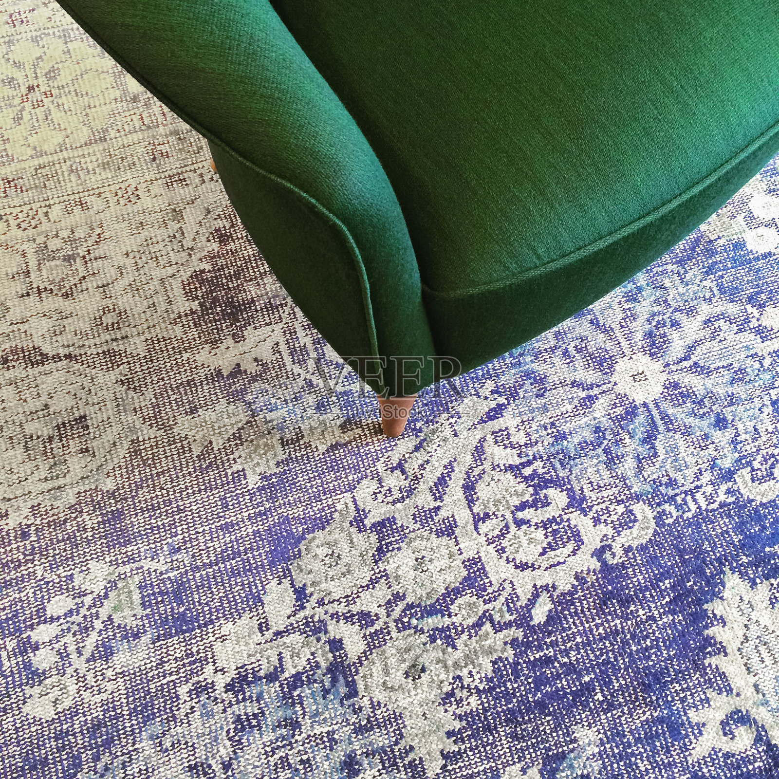 蓝色复古地毯上的绿色扶手椅照片摄影图片