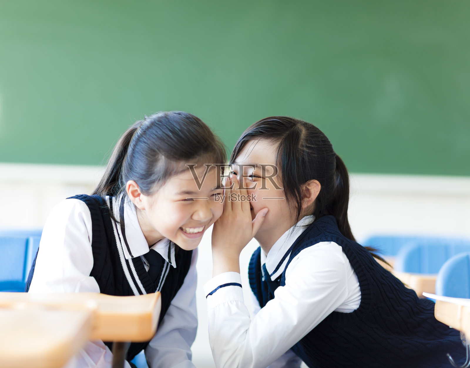 两个少女在教室里闲聊照片摄影图片