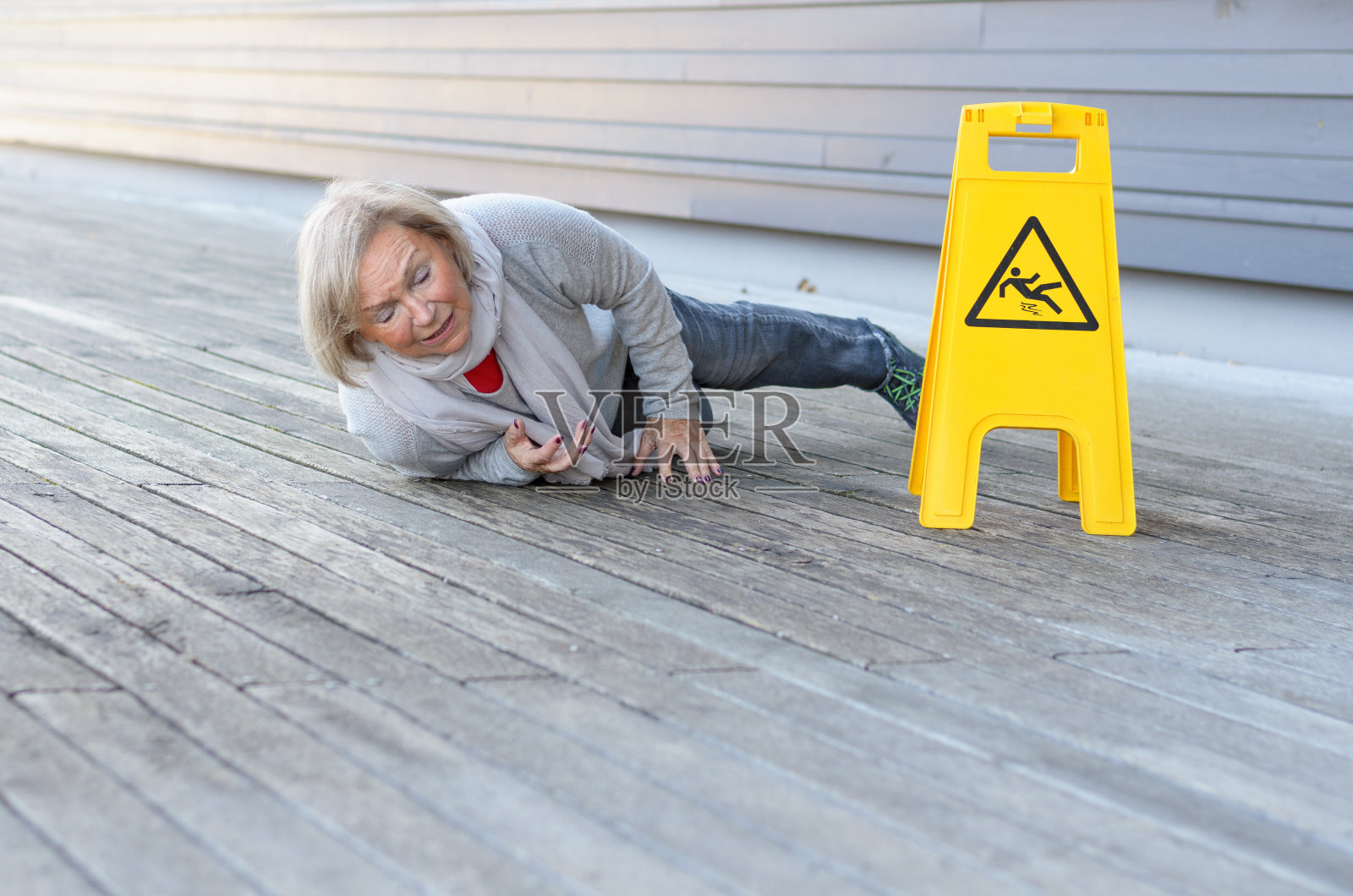 老妇人滑倒在潮湿的地面上照片摄影图片
