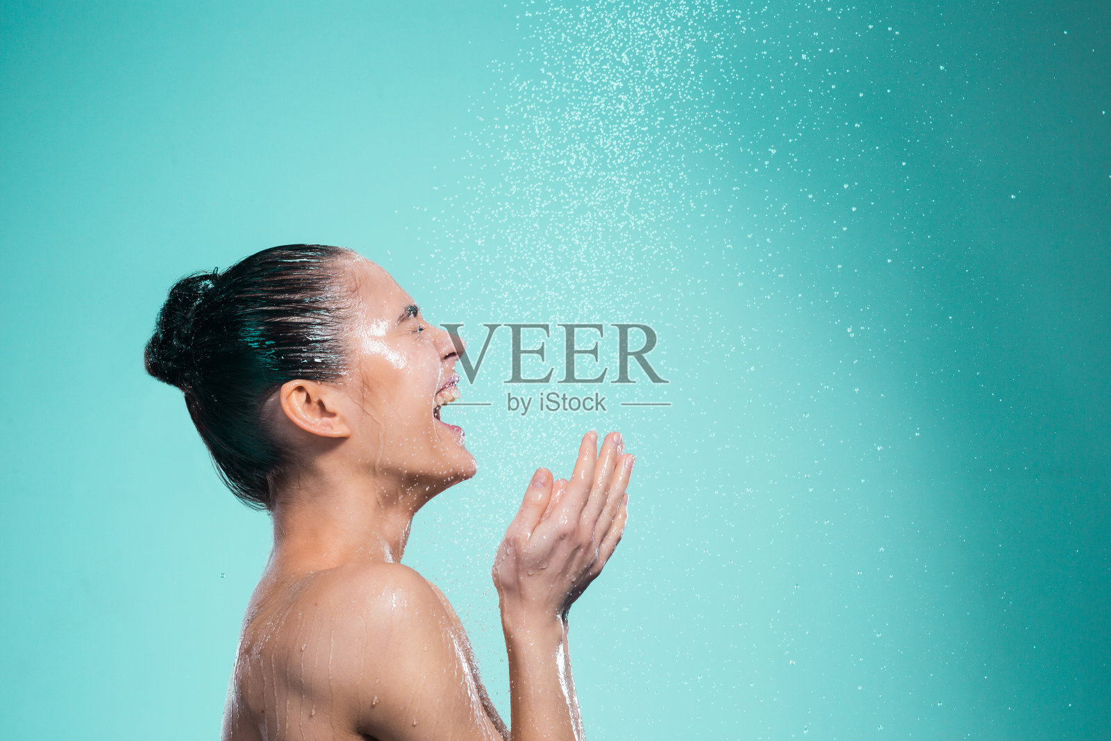 在喷水下享受淋浴的女人照片摄影图片