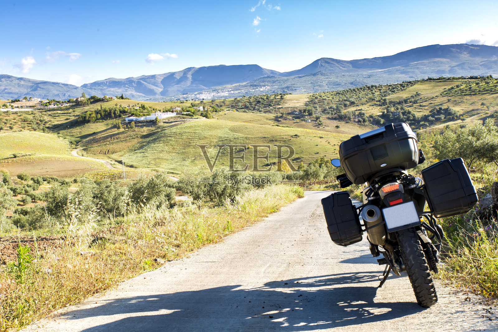 摩托车行驶在乡间小路上，映衬着夏日的风景照片摄影图片